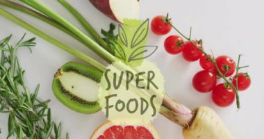 Süper yiyecekler beyaz arka planda taze meyve ve sebzeler üzerine animasyon metinleri yazıyor. Sağlıklı, beslenme, organik, taze ürün, vitamin, diyet