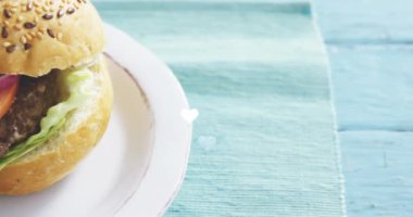 Kalp animasyonu, beyaz tabakta leziz hamburgerin yakın planında. Yemek, iştah açıcı, gurme, yemek, sevgililer günü, lezzetli