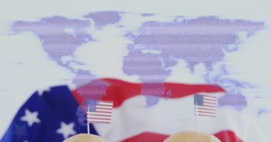 Amerikan bayrağı üzerinde dünya haritası animasyonu ve küçük Amerikan bayraklı hamburgerler. Vatanseverlik, kutlama, Bağımsızlık Günü, aşçılık, fast food, vatanseverlik