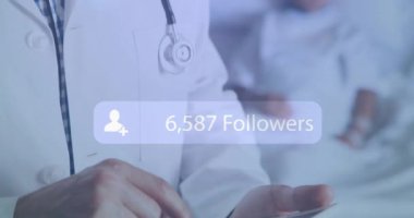 156.250 takipçisi olan beyaz önlüklü doktor arka plandaki hastadan animasyonu azaltıyor. Sağlık, profesyonel, sosyal medya, dijital, tıbbi, çevrimiçi