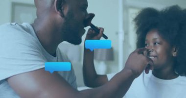 Gülümseyen adam ve çocuğun kapalı mekanda etkileşimi üzerine sohbet baloncukları. İletişim, etkileşim, teknoloji, aile, bağ, sohbet