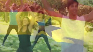 Park 'ta egzersiz yaparken, arka planda Gana bayrağı animasyonu olan insanlar. Spor, egzersiz, açık hava, grup, ulusal bayrak, vatanseverlik
