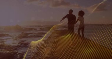 Okyanusu gösteren, sahnenin üzerinde dijital dalga animasyonuyla kayaların üzerinde duran çift. Sahil, sahil, dijital sanat, teknoloji, romantizm, macera