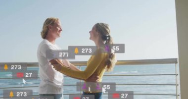 Okyanus tarafından kucaklanan çiftler hakkında sosyal medya bilgilendirmeleri. Romantizm, kucak, teknoloji, bağlantı, aşk, ilişki