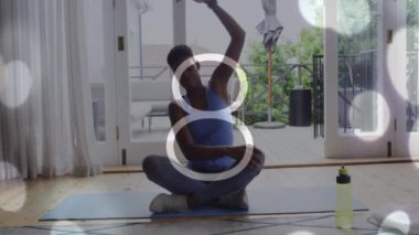 Yoga minderi üzerinde meditasyon yapan, Bokeh Light animasyonu üzerinde akıllı seğiren biri. Meditasyon, sağlık, rahatlama, teknoloji, farkındalık konsepti