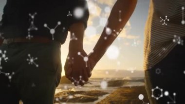 Gün batımında el ele tutuşan, moleküler yapı animasyonu olan çift, okyanus arka planında. Aşk, kimya, romantizm, ilişki, bağlantı, bilim