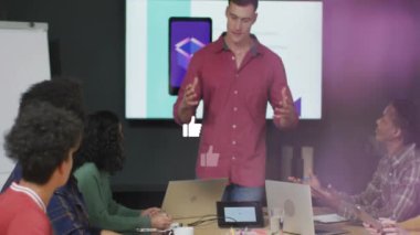 Sosyal medyayla çevrili adam, ofisteki meslektaşlarına animasyon sever. İş, sunum, takım çalışması, işbirliği, profesyonel, toplantı