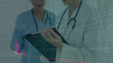 Doktorlar tabletteki verileri finansal grafikler ve çizelgeler üzerinden analiz ediyorlar. Sağlık, takım çalışması, teknoloji, finans, analiz, profesyoneller