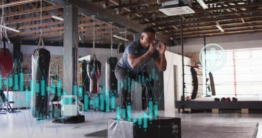 Finansal veriler ve borsa görüntüsü spor salonunda egzersiz yapan bir adam üzerinde. Finans, teknoloji, egzersiz, fitness, iş, analitik