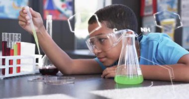 Kimyasal formüller üzerinde pipet kullanan güvenlik gözlüklü bir çocuk. laboratuvar, çocuklar, eğitim, kimyasallar, araştırma, öğrenme