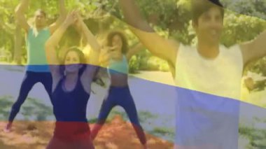 Açık havada egzersiz yaparken, üzerinde Kolombiya bayrağı olan insanlar. Fitness, egzersiz, milliyet, kutlama, kültür, çeşitlilik