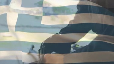 Açık havada tüfeği tutan kişinin Yunan bayrağı animasyonu. Yunanistan, vatanseverlik, milliyetçilik, açık hava, askeri