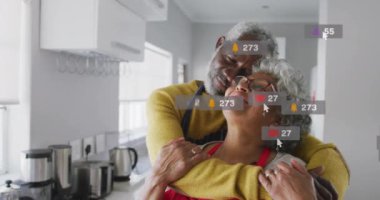 Sosyal medya etkileşimi, yaşlı çiftin mutfakta kucaklaşması üzerine animasyon simgeleri oluşturuyor. Aşk, aile, birliktelik, online, kalp, iletişim