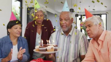 Pastalı bir grup insan üzerinde konfeti animasyonuyla doğum günü kutlaması. Mutluluk, arkadaşlar, neşe, eğlence, birliktelik, olay kavramı