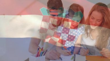 Arka planda Hırvat bayrağı animasyonu olan bir aile, masada birlikte çizim yapıyor. Beraberlik, bağlılık, kutlama