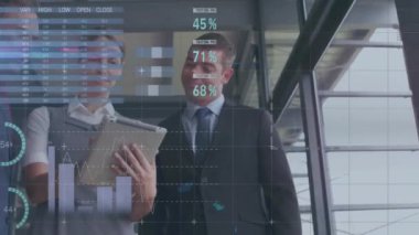 Tablet üzerindeki verileri tartışan iş adamları, finansal istatistik animasyonlarını üst üste koydular. Takım çalışması, işbirliği, teknoloji, dijital, finans, veri analiz kavramı