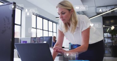 Sosyal medya simgeleri ve dizüstü bilgisayar kullanan Kafkas iş kadını üzerindeki numaralar. Sosyal medya, iş dünyası, bağlantılar ve dijital olarak oluşturulan veri işleme kavramı.