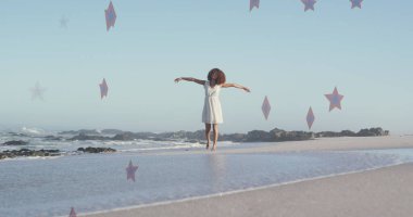 Sahilde elini kaldıran Afrikalı Amerikalı bir kadının üzerindeki yıldızların görüntüsü. Vatanseverlik ve kutlama konsepti dijital olarak oluşturulmuş imaj.