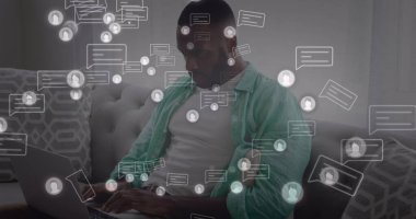 Mesaj ve profil ikonlarının resmi, Afro-Amerikan bir adam kanepede oturuyor ve bilgisayarla çalışıyor. Dijital bileşik, çoklu pozlama, ev, bildirim, sosyal medya ve teknoloji kavramı