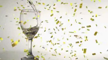 Beyaz arka planda beyaz şarap bardağında konfeti animasyonu. İçki, kutlama ve parti konsepti, dijital olarak üretilen video.