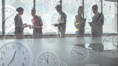 Ofiste iş tartışan çeşitli meslektaşların üzerinde hareket eden saatlerin animasyonu. İş ve dijital arayüz kavramı, dijital olarak oluşturulmuş video.