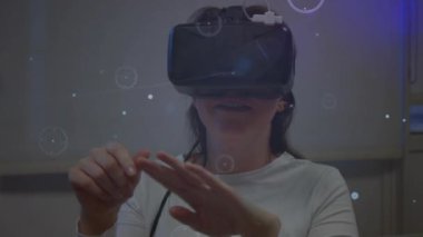 Sanal arayüz animasyonu olan bir kadın, VR kulaklık ve etkileşim kullanıyor. Teknoloji, sanal gerçeklik, etkileşim, dijital, yenilik, artırılmış gerçeklik
