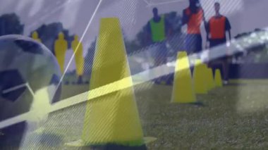 Futbol antrenmanında sarı koni ve çim tarlasında kod animasyonu programlanıyor. Teknoloji, yazılım, kodlama, animasyon, spor, futbol