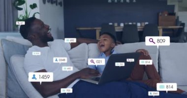 Sosyal medya analitik animasyonu baba ve oğulun koltukta dizüstü bilgisayar kullanması üzerine. Teknoloji, aile, bağlanma, veri, ölçüler, ebeveynlik