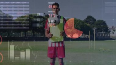 Futbol topunu tutan atlet, sahada veri canlandırma animasyonuyla duruyor. spor, teknoloji, aksiyon