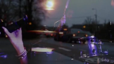 Gitar ve davul çalan müzisyenler, alacakaranlıkta arabaların üzerinde animasyon yapıyorlar. enstrümanlar, performans, trafik, sokak, araçlar, akşam