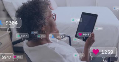 Tablet kullanarak, tekerlekli sandalyedeki kişi sosyal medya bilgilendirmeleriyle animasyon yapıyor. Erişilebilirlik, teknoloji, iletişim, hareketlilik, dijital eklenti, etkileşim