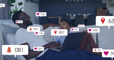 Baba ve oğlunun kanepede gülüşü üzerine sosyal medya animajı. Teknoloji, aile, bağ, oturma odası, mutluluk, dijital