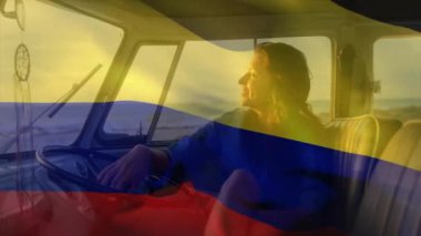 Sahilde karavanda oturan, elinde Kolombiya bayrağı sallayan bir kadın. seyahat, macera, yaz, özgürlük, tatil, açık hava