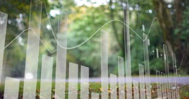 Finansal veri tabloları, ağaçlar ve yapraklarla bulanık bir açık hava parkı sahnesinin animasyonunu gösteriyor. Finans, teknoloji, analitik, yatırım, iş, büyüme