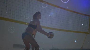 Plaj voleybolu oynarken, insanlar canlı ağ bağlantılarında topa atlamak için zıplıyorlar. Spor, takım çalışması, bağlantı, teknoloji, açık hava, spor