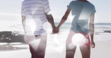 El ele tutuşmak ve sahilde yürümek, Bokeh Light animasyonunun üzerinde bir çift. Romantizm, birlikte, aşk, günbatımı, yürüyüş, ilişki