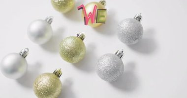 Beyaz arka planda Noel süsleri eşliğinde mutlu noel mesajları animasyonu. Tatil, şenlik, kutlama, kış, selamlama, süsleme