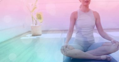 Yoga minderi üzerinde meditasyon yapan, sakinleştiren bokeh geçmişi olan bir kadın. Sağlık, farkındalık, rahatlama, meditasyon, sükunet, sükunet.