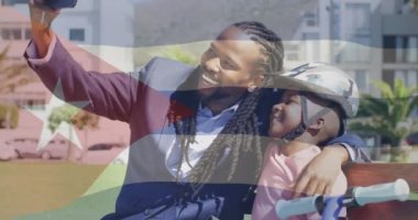 Arka planda Küba bayrağı animasyonu olan baba ve oğul selfie çekiyoruz. Aile, birliktelik, vatanseverlik, babalık, bağlılık, gurur.