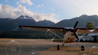 6G ağ animasyonlu asfalt üzerinde küçük bir uçak. Havacılık, teknoloji, bağlantı, iletişim, dağlar, manzara