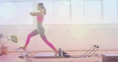 Pilates yenilikçileri üzerinde egzersiz yapan kadın, Bokeh Light animasyonunun üzerinde geriniyor. Fitness, egzersiz, esneklik, egzersiz, sağlıklı yaşam tarzı, sağlık