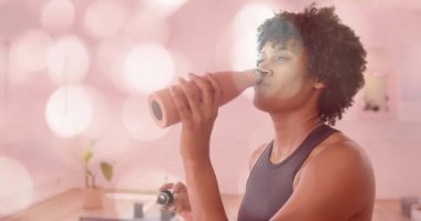 Şişeden içen, pembe bokeh animasyon geçmişi olan bir kadın. İçecek, su, yaşam tarzı, içecek, renkli, dijital.
