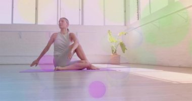 Paspasın üzerinde yoga yapıyor, parlak stüdyoda renkli Bokeh animasyonlu bir kadın. Zindelik, fitness, meditasyon, egzersiz, pilates, esneklik