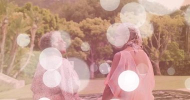 Bokeh hafif animasyon. Bahçede içki içen iki kadın. Arkadaşlık, kutlama, açık hava, gece hayatı, rahatlama, parti