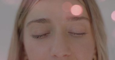 Yüzünde Bokeh ışıkları olan gülümseyen bir kadının yakın çekimi. Yakın plan, portre, neşeli.