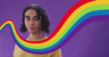 Barış işareti hareketi yapan, arka planda gökkuşağı dalgası animasyonu olan kişi. LGBTQ, gurur, birlik, kutlama, çeşitlilik, renkli
