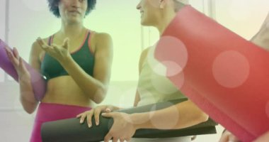 Yoga minderleri tutan ve sohbet eden kadınlar, onların üzerinde bokeh ışığı animasyonu olan kadınlar. Sağlık, fitness, egzersiz, grup, sohbet, sağlıklı