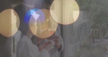 Çay içip sohbet ediyorlar. Bokeh Light animasyonlu bornozlu bir çift. Rahatlama, rahatlama, sohbet, konfor, yaşam tarzı, kaynaşma