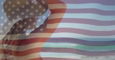 Sahil manzarasının tadını çıkaran, arka planda Amerikan bayrağı animasyonu olan bir kadın. Vatanseverlik, tatil, özgürlük, ABD, kutlama, eğlence konsepti