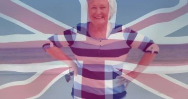 Arka planda Union Jack animasyonuyla sahilde gülümseyen kadın. Tatil, vatanseverlik, tatil, özgürlük, yaz, İngiliz